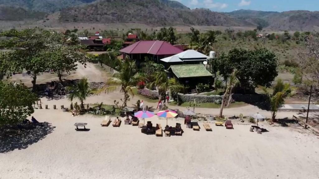 eine Luftansicht auf einen Strand mit Stühlen und Sonnenschirmen in der Unterkunft Rock Pool Homestay in Huu