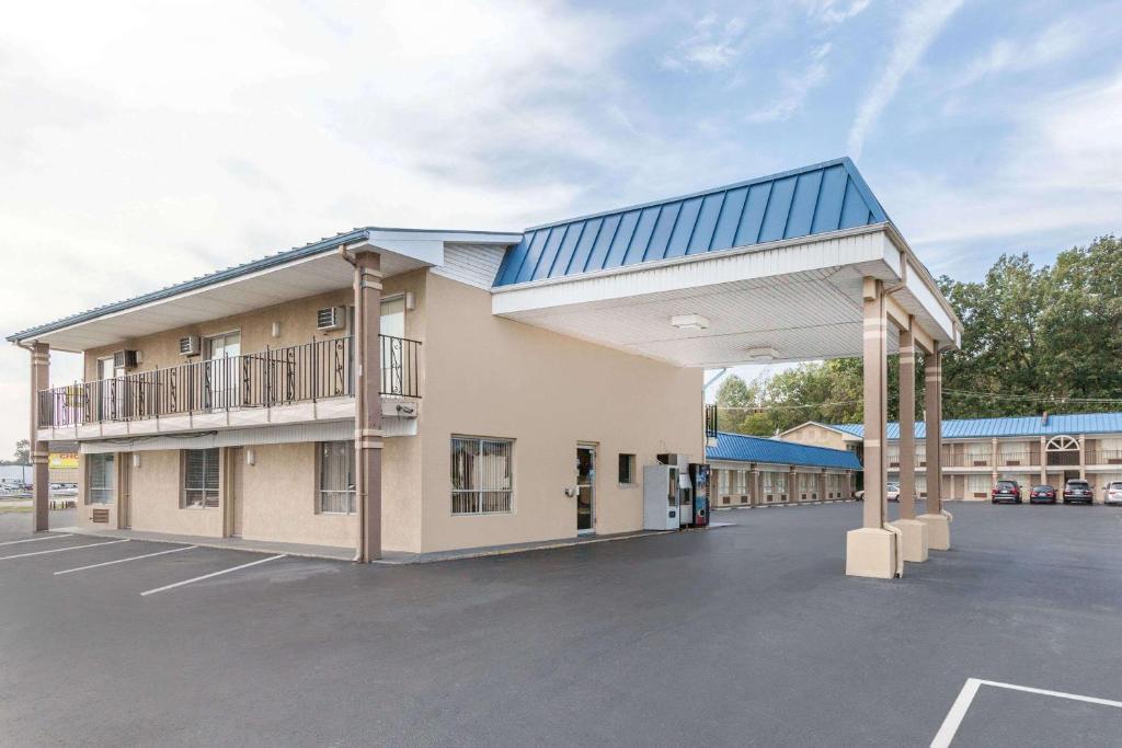 a large building with a blue roof and a parking lot at Days Inn by Wyndham Jacksonville in Jacksonville