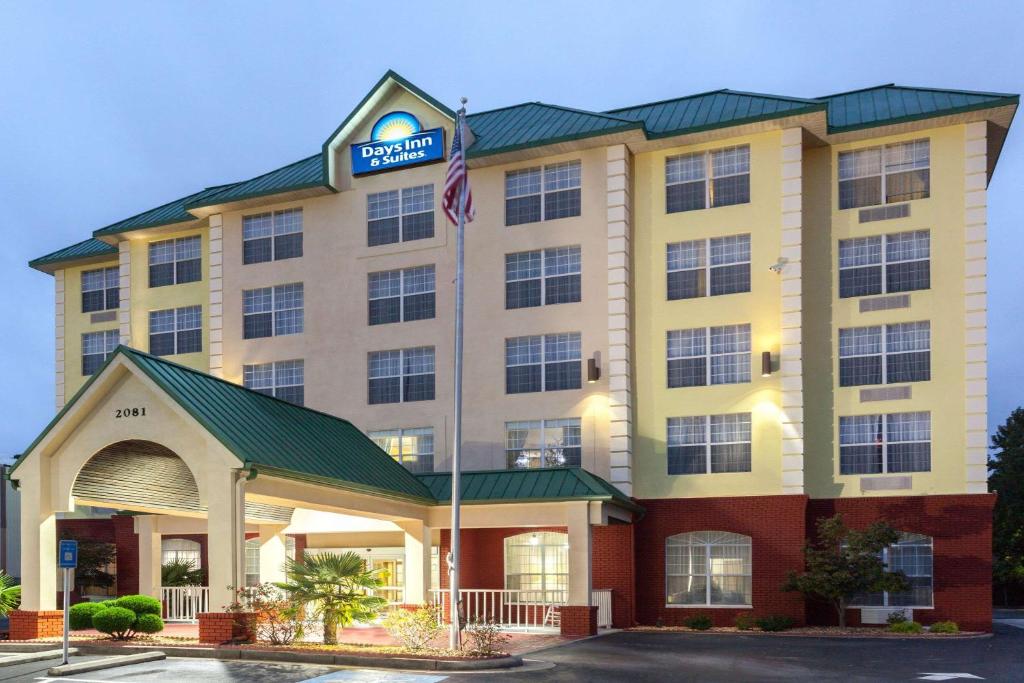 a hotel with a sign on the front of it at Days Inn & Suites by Wyndham Tucker/Northlake in Tucker