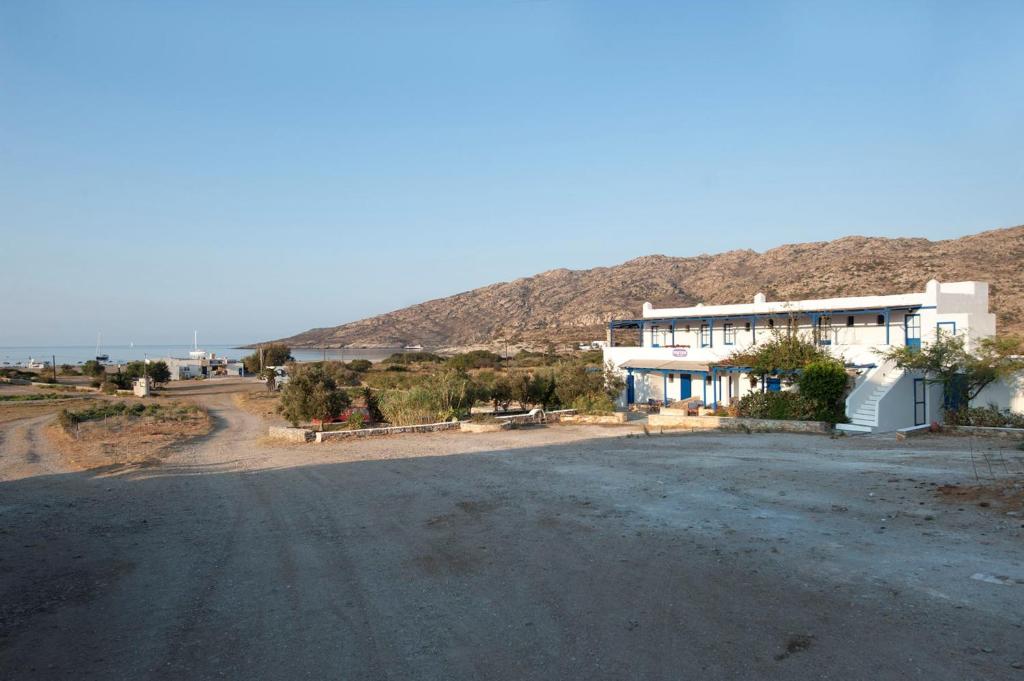 uma casa ao lado de uma estrada de terra em Dimitris Rooms em Manganari