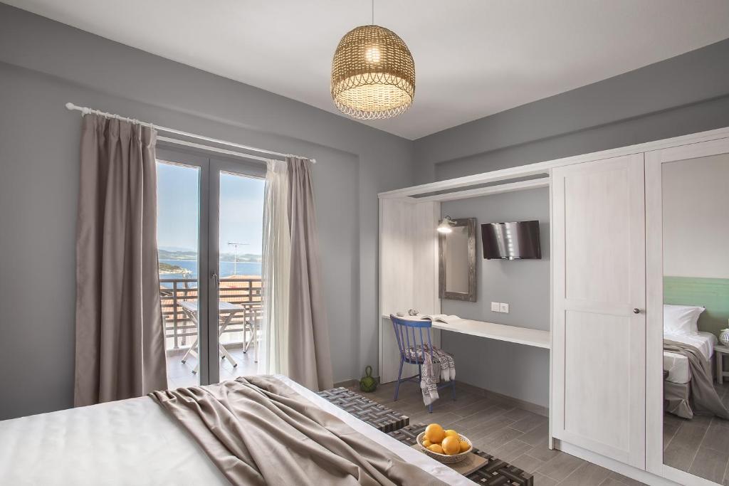 een slaapkamer met een bed en uitzicht op de oceaan bij Nissos Rooms Ammouliani in Amoliani