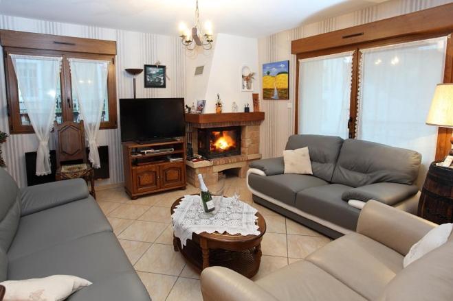 a living room with two couches and a fireplace at La Pousada in Dormans