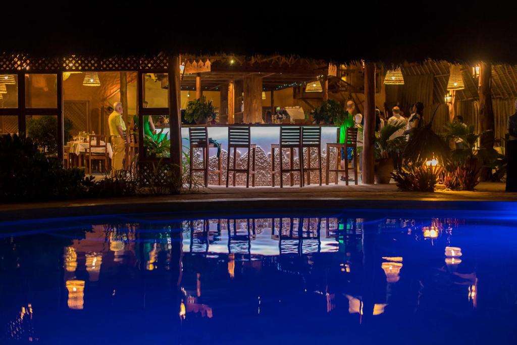 a night view of a swimming pool at a restaurant at Zanzibar Queen Hotel in Matemwe