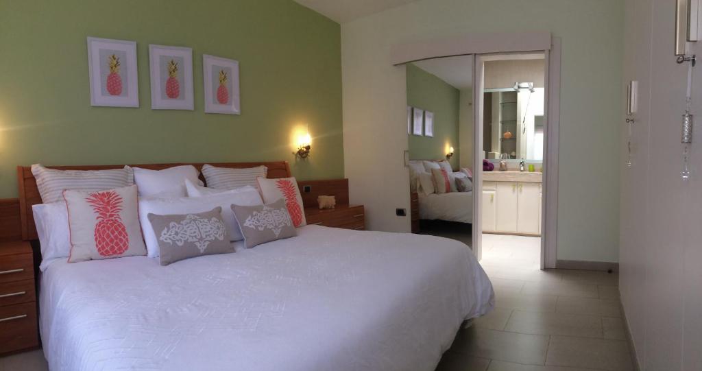 a bedroom with a bed with pink and white pillows at Villa Flamboyan in Mogán