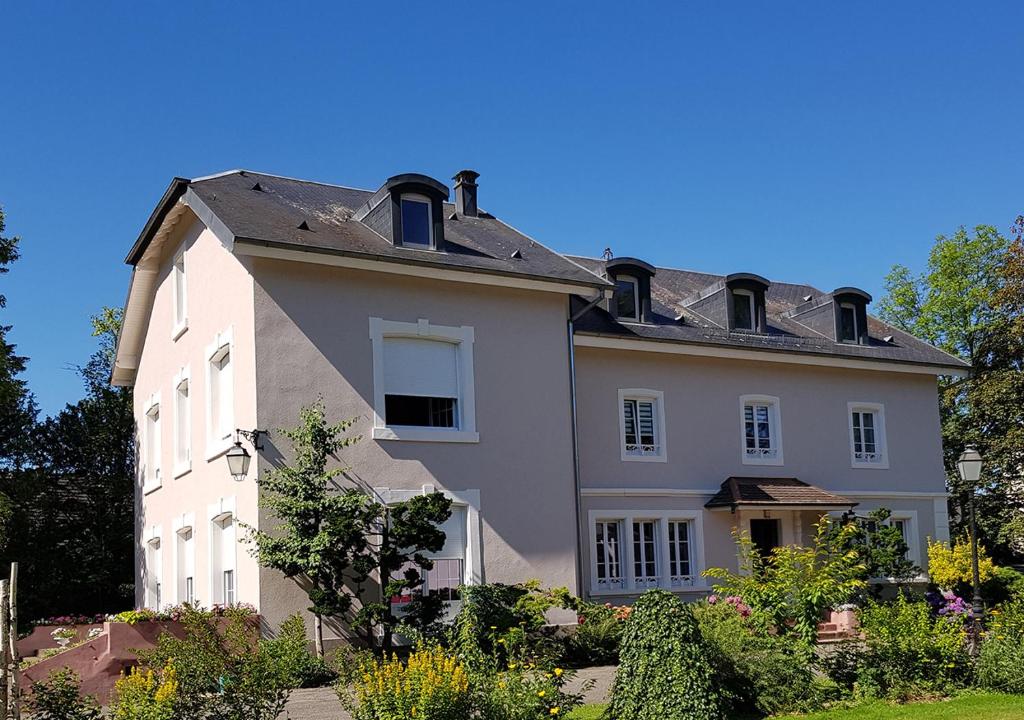 a large white house with a roof at La Roseraie in Sentheim