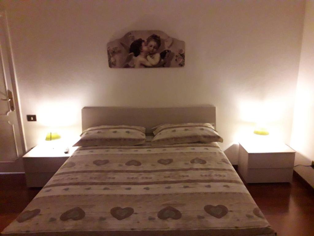 una camera da letto con un letto con due comodini e una foto sul muro di Santo Spirito 2 - by Nadia ad Arezzo