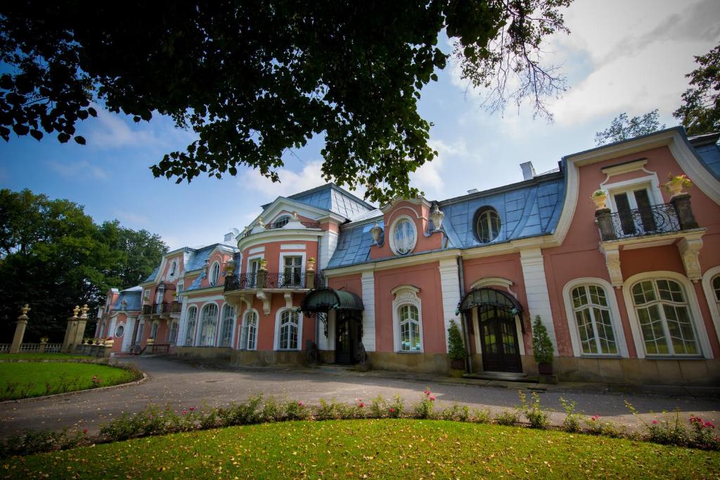 a large pink building with a blue roof at U Schabińskiej - Pałac w Gorlicach in Gorlice