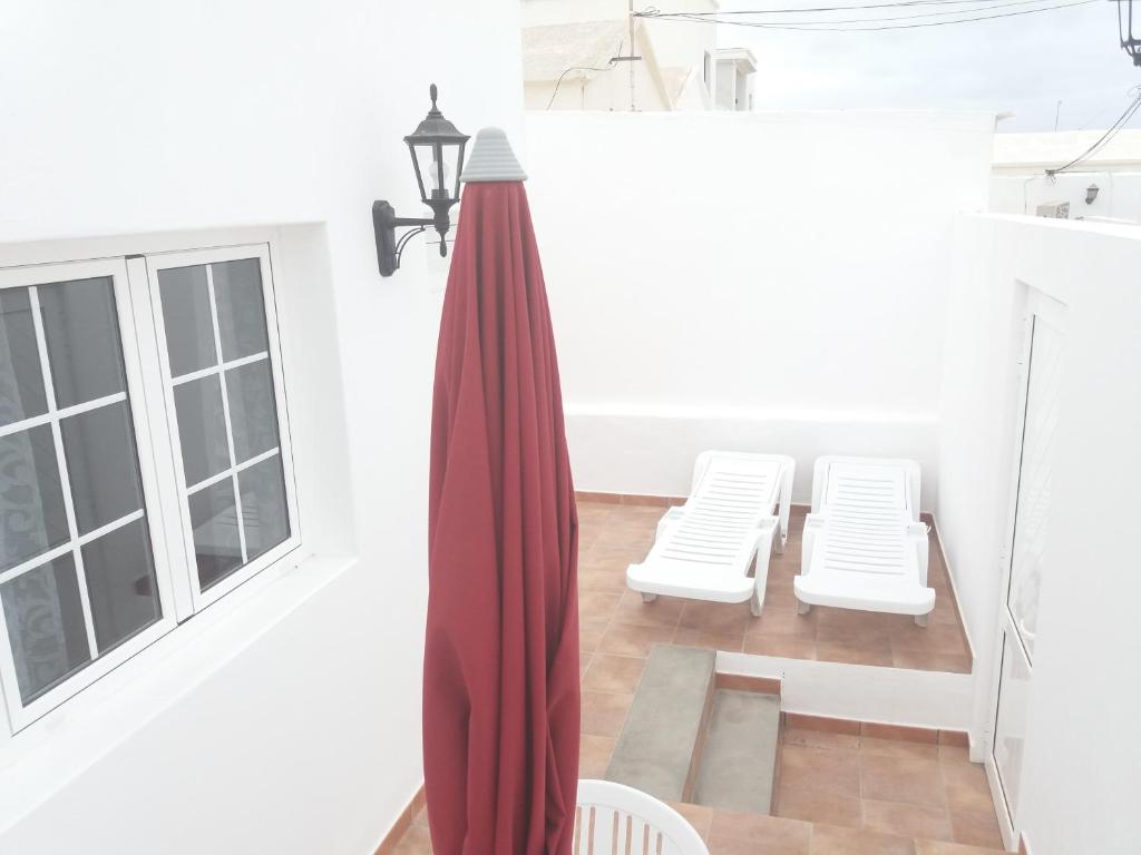 a room with two white chairs and a red curtain at Casa Olivina 2 in Puerto del Carmen