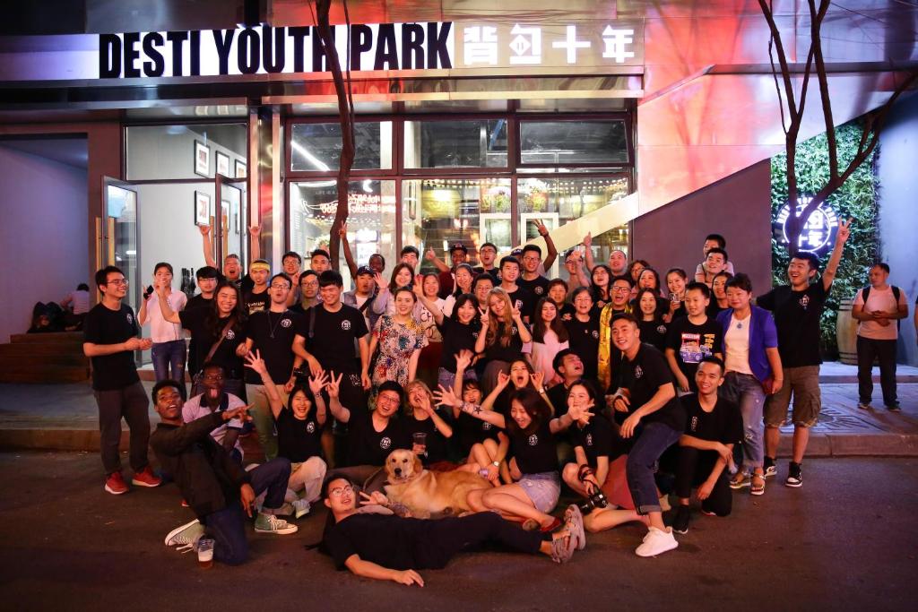 a group of people posing for a picture in front of a building at Chengdu Desti Youth Park Hostel in Chengdu