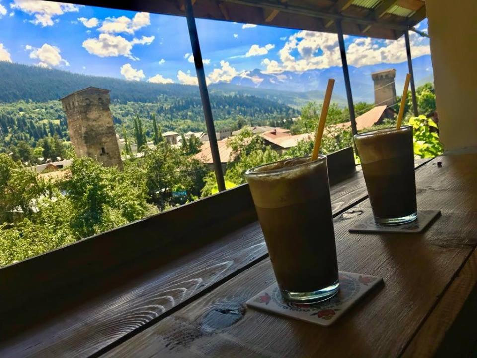 two drinks sitting on a table in front of a window at Guesthouse Chela in Mestia