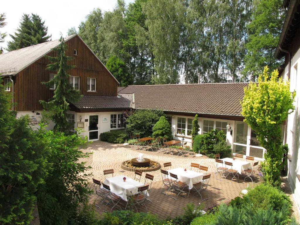 eine Luftansicht eines Hauses mit Tischen und Stühlen in der Unterkunft Land-gut-Hotel Zur Lochmühle in Penig