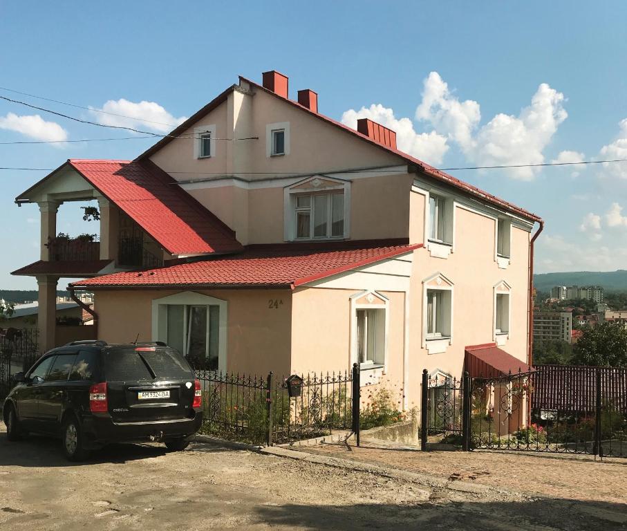 a house with a car parked in front of it at Hercules in Truskavets