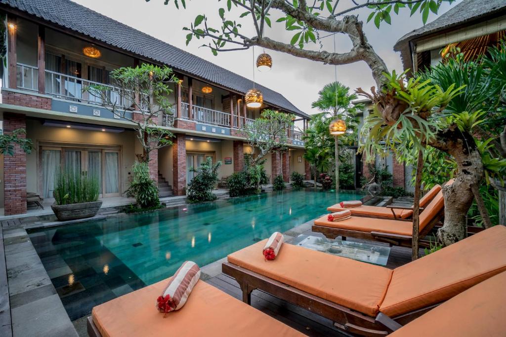 an infinity pool in a villa with lounge chairs at Tetirah Boutique Hotel in Ubud