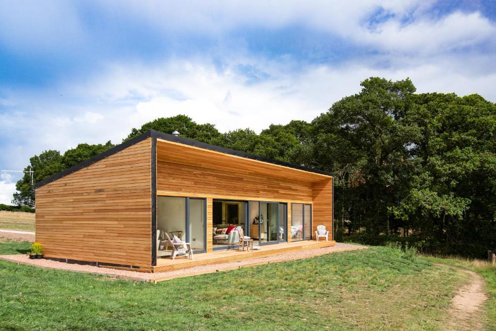 a small wooden house on a grass field at Eden Hideaway in Kelso