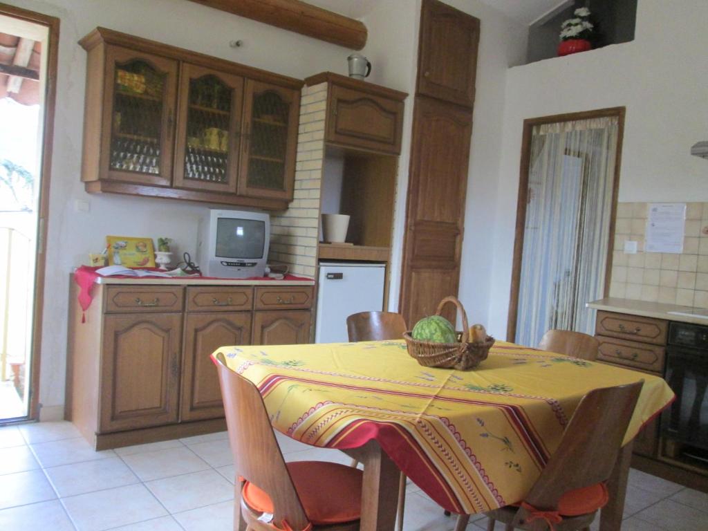 a kitchen with a table with a basket on it at Gîtes des Cèdres in Crestet