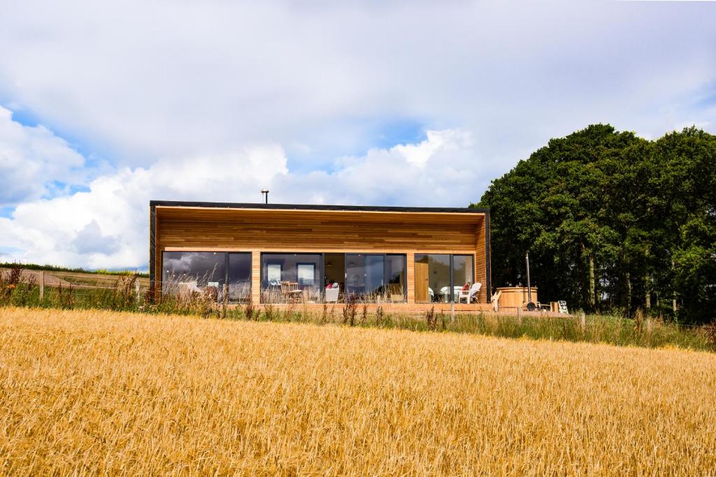 uma casa sentada em cima de um campo em Tweed Hideaway em Kelso