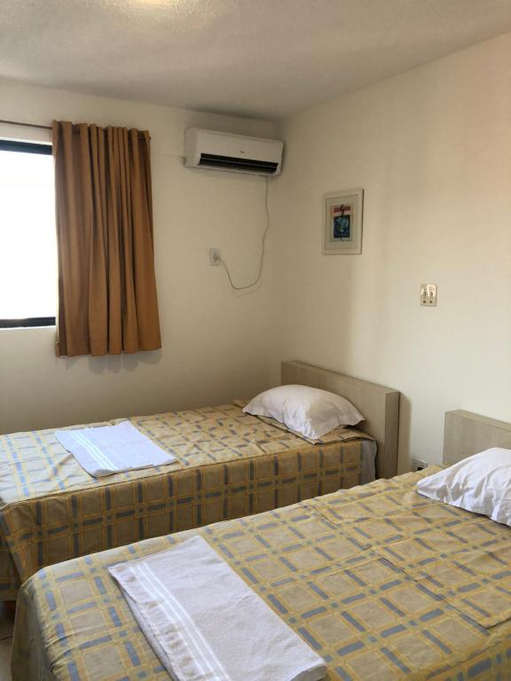 Rúm í herbergi á Melo Hospedagem - Flat Bellagio