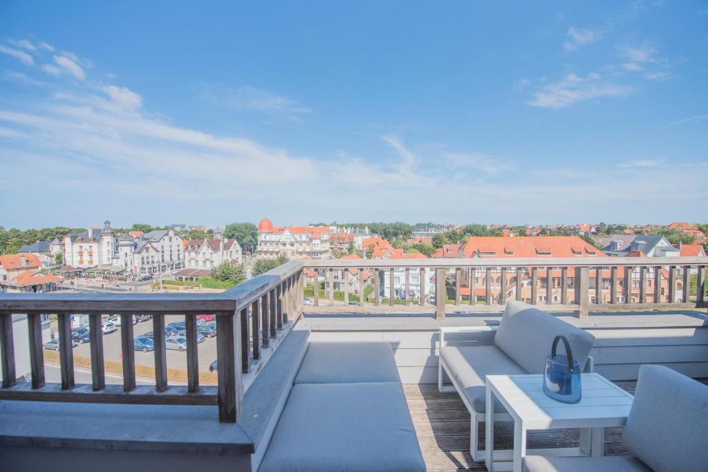 a balcony with a couch and a table at Point De Vue in De Haan