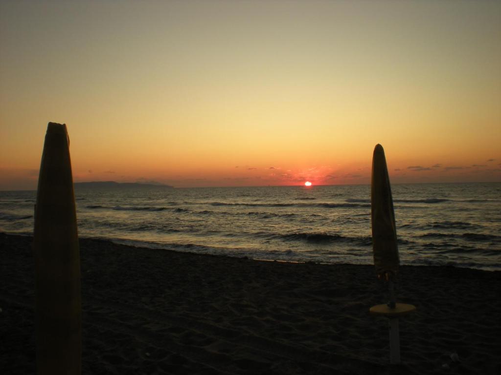 two umbrellas on the beach with the sunset at Brezza Di Grecale in Trapani
