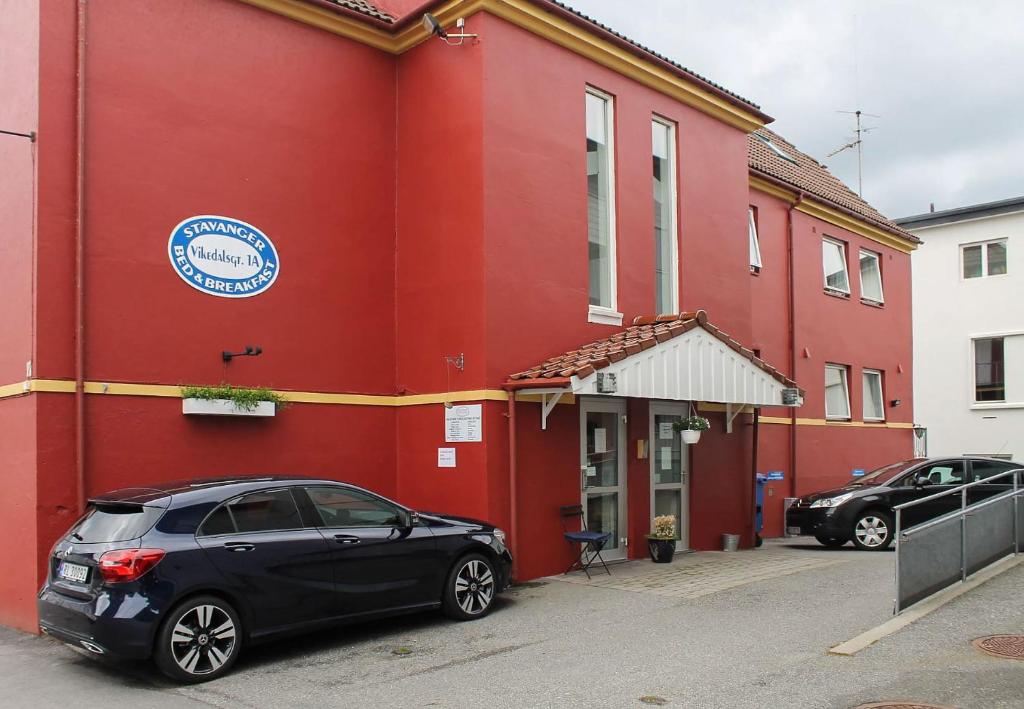 a black car parked in front of a red building at Stavanger Bed & Breakfast in Stavanger