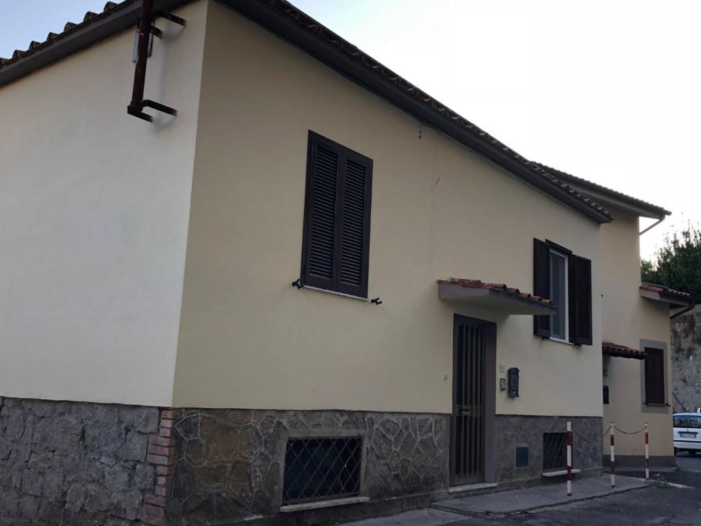 a white building with black shutters on it at CASALE PRATOTERRA 2 in Bracciano