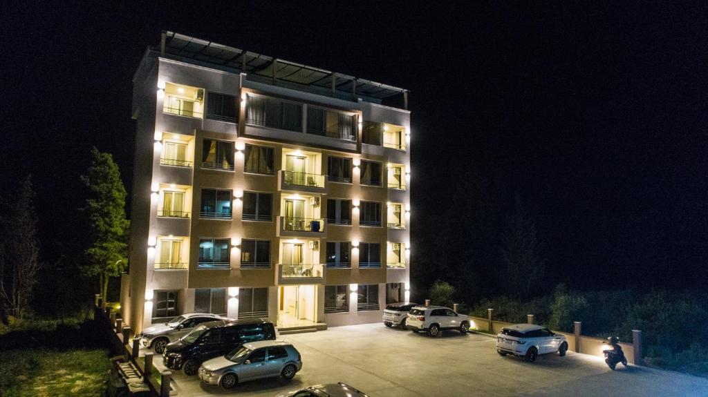 a building with cars parked in a parking lot at night at Vista Apartments in Ulcinj