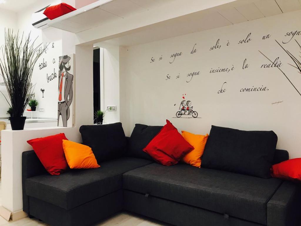 - un salon avec un canapé noir et des oreillers colorés dans l'établissement Isola Flat, à Milan