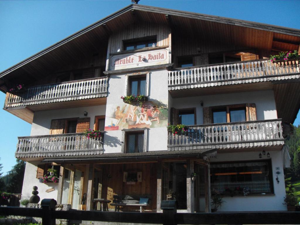 a building with balconies on the side of it at Garni Meublè La Baita in Val di Zoldo