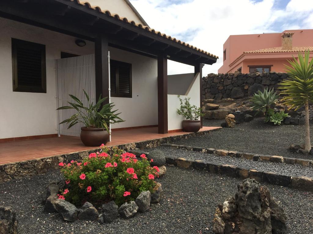 une maison avec quelques fleurs dans une cour dans l'établissement Casa Carlotta Lajares, à Lajares