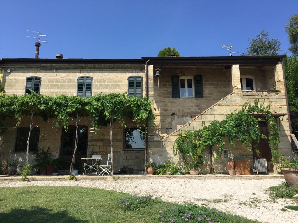 una vecchia casa in pietra con un mucchio di viti di Agriturismo Montedago ad Ancona