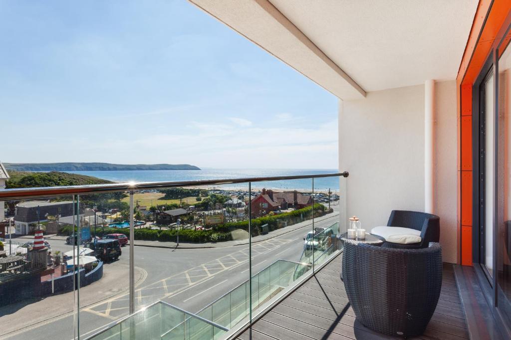a balcony with a view of a street and the ocean at 11 Woolacombe West - Luxury Apartment at Byron Woolacombe, only 4 minute walk to Woolacombe Beach! in Woolacombe