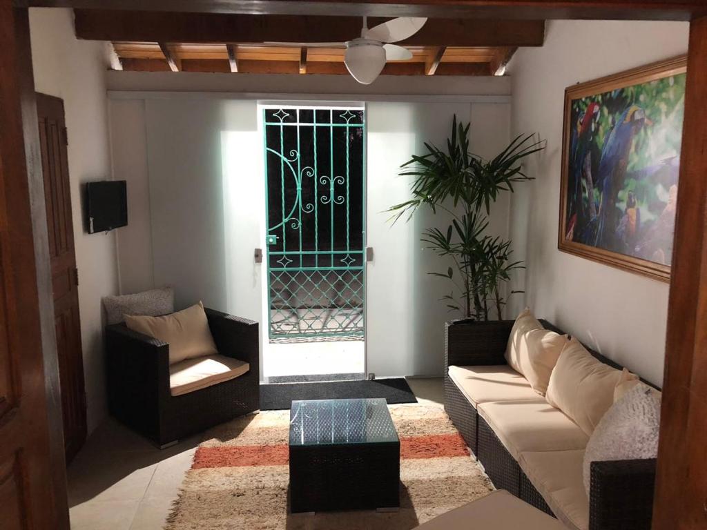 ein Wohnzimmer mit einer Couch und einem Fenster mit einem Tor in der Unterkunft Casa a 100mts da praia in Ilhabela