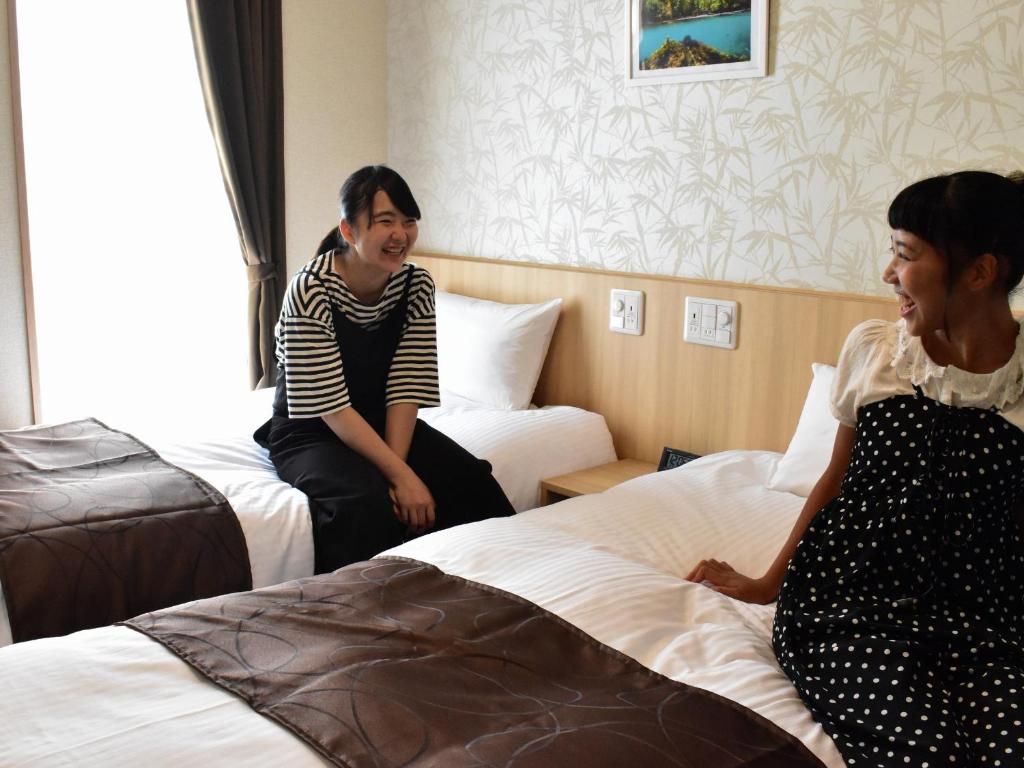 Postel nebo postele na pokoji v ubytování TABINO HOTEL Sado