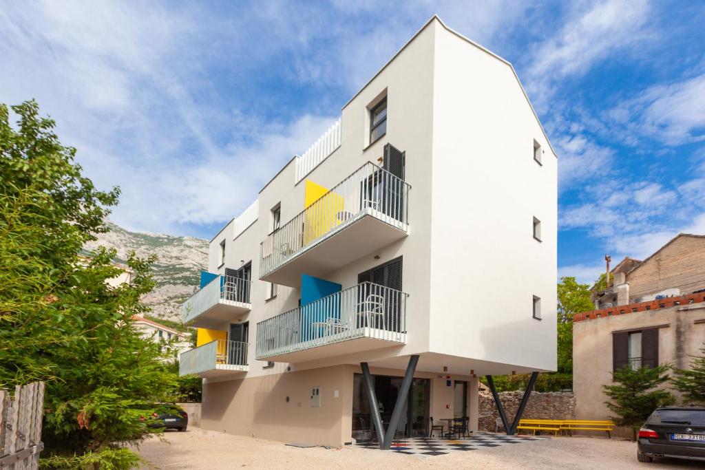 a white building with balconies on it at SUBTUB Hostel Makarska in Makarska