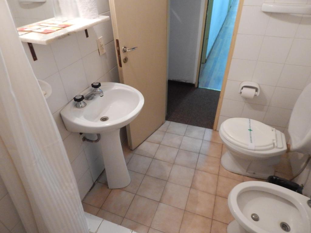 a small bathroom with a toilet and a sink at Residencial Ski in Esquel