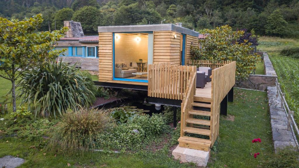 a tiny house with a wooden deck in a yard at A Cabana de Carmen in Cabana Moura 