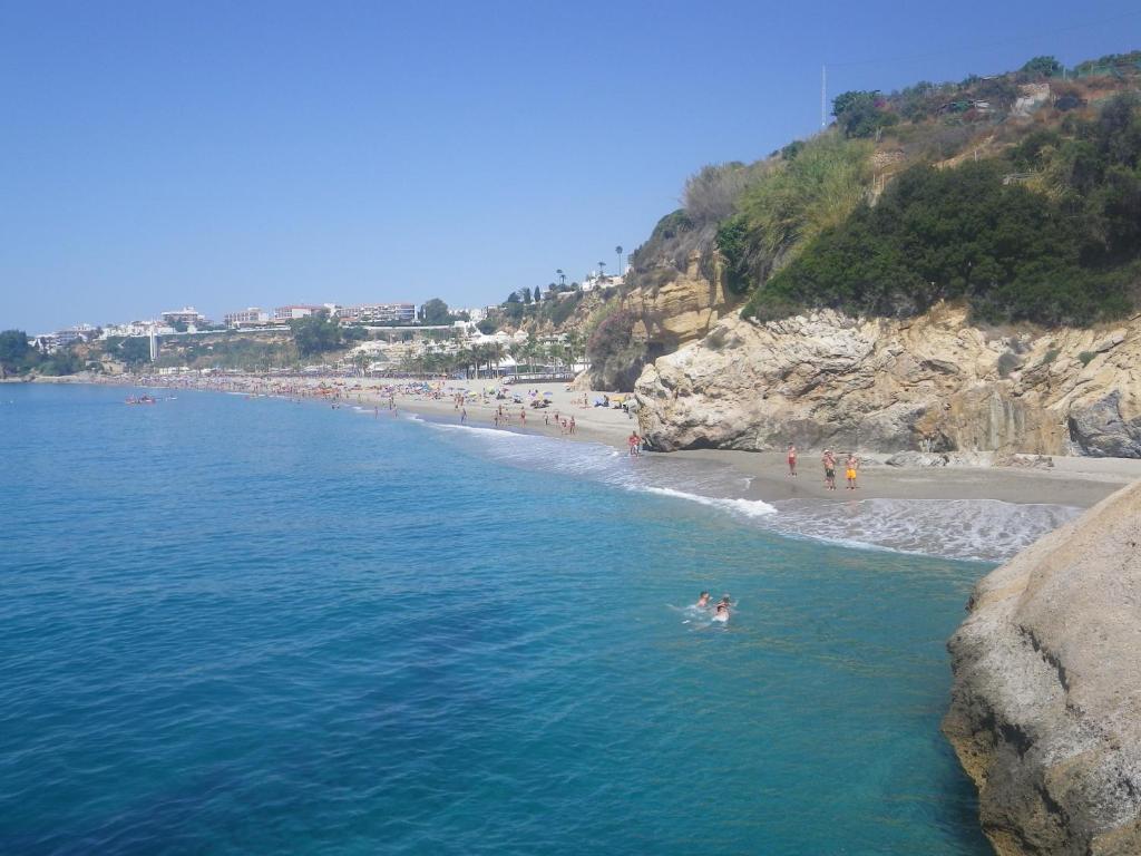 an aerial view of a beach with people in the water at Apartment Burriana in Nerja