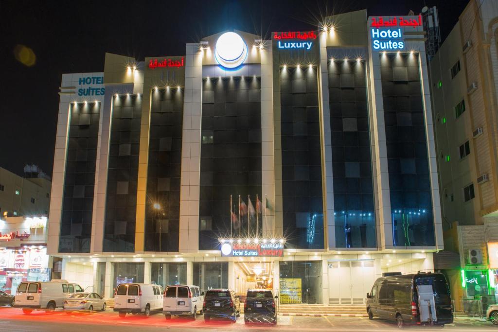 a building with cars parked in front of it at night at Luxury hotel apartments in Tabuk