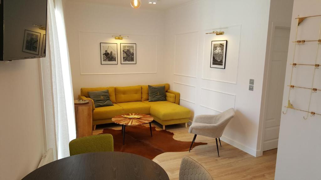 a living room with a yellow couch and a table at 123 Sadi Carnot, classé 2 étoiles in Saint-Raphaël
