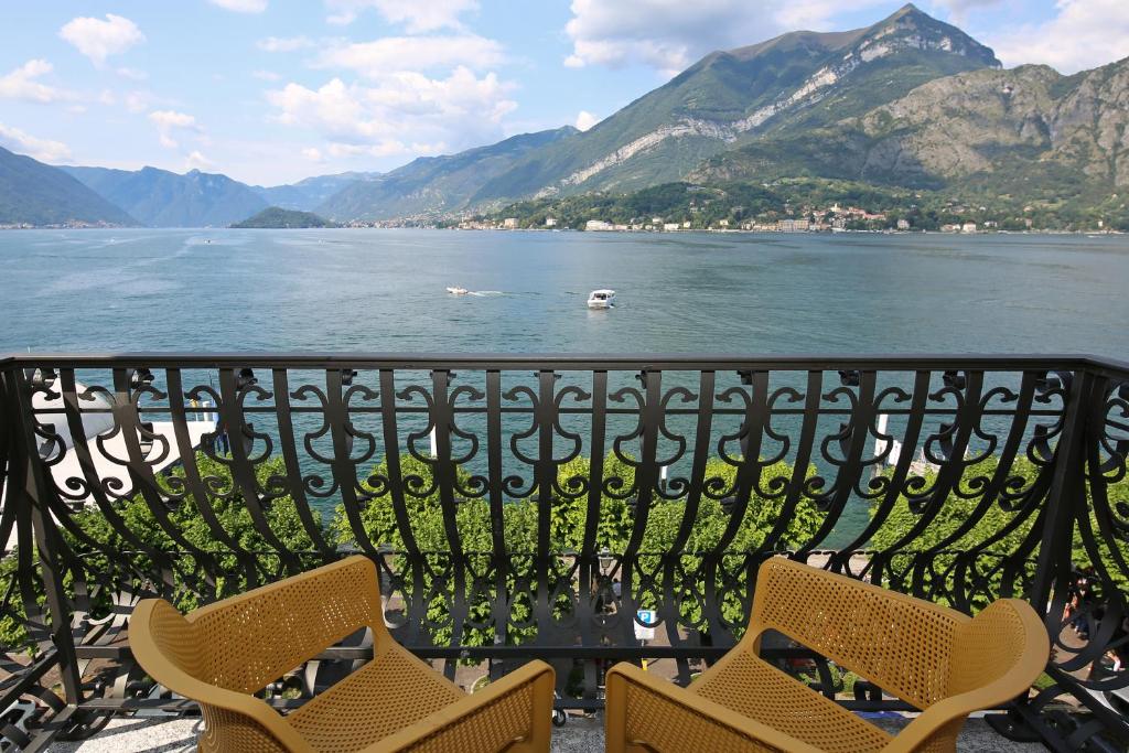 einen Balkon mit Stühlen und Blick auf das Wasser in der Unterkunft palazzo barindelli suite verde in Bellagio