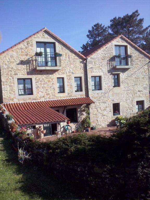 a large stone building with windows and a balcony at Casa pedrolo in Outes