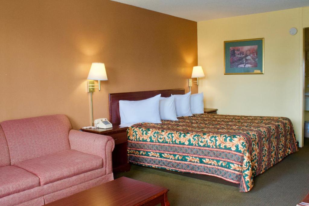 a hotel room with a bed and a couch at Relax Inn - Monroe in Monroe