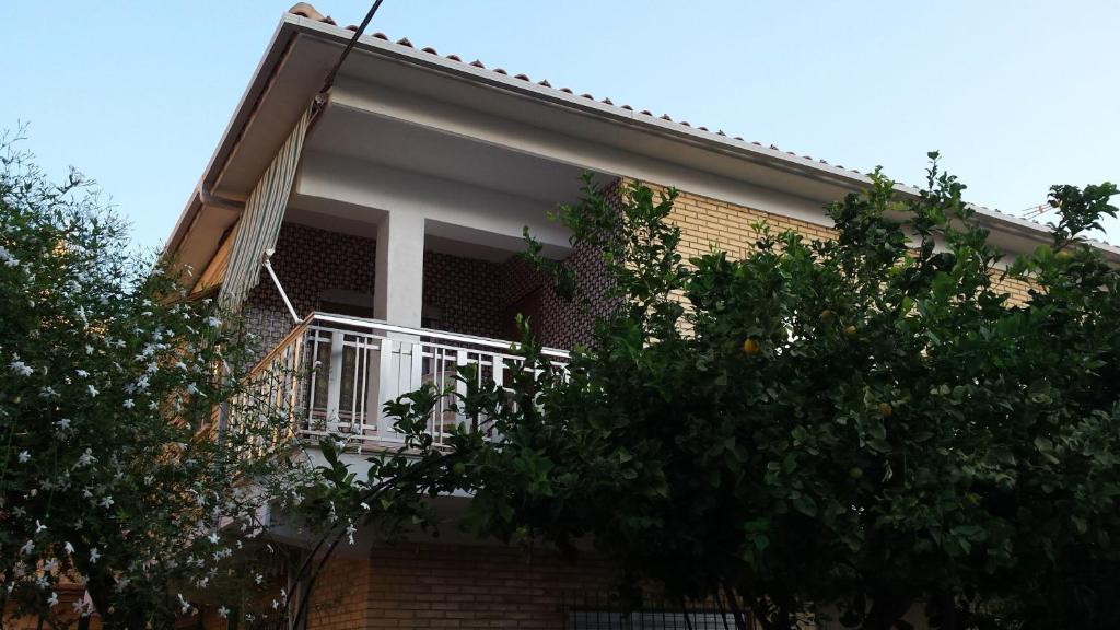 a balcony on the side of a house with trees at Viviendas Moreno Mar Menor in Santiago de la Ribera