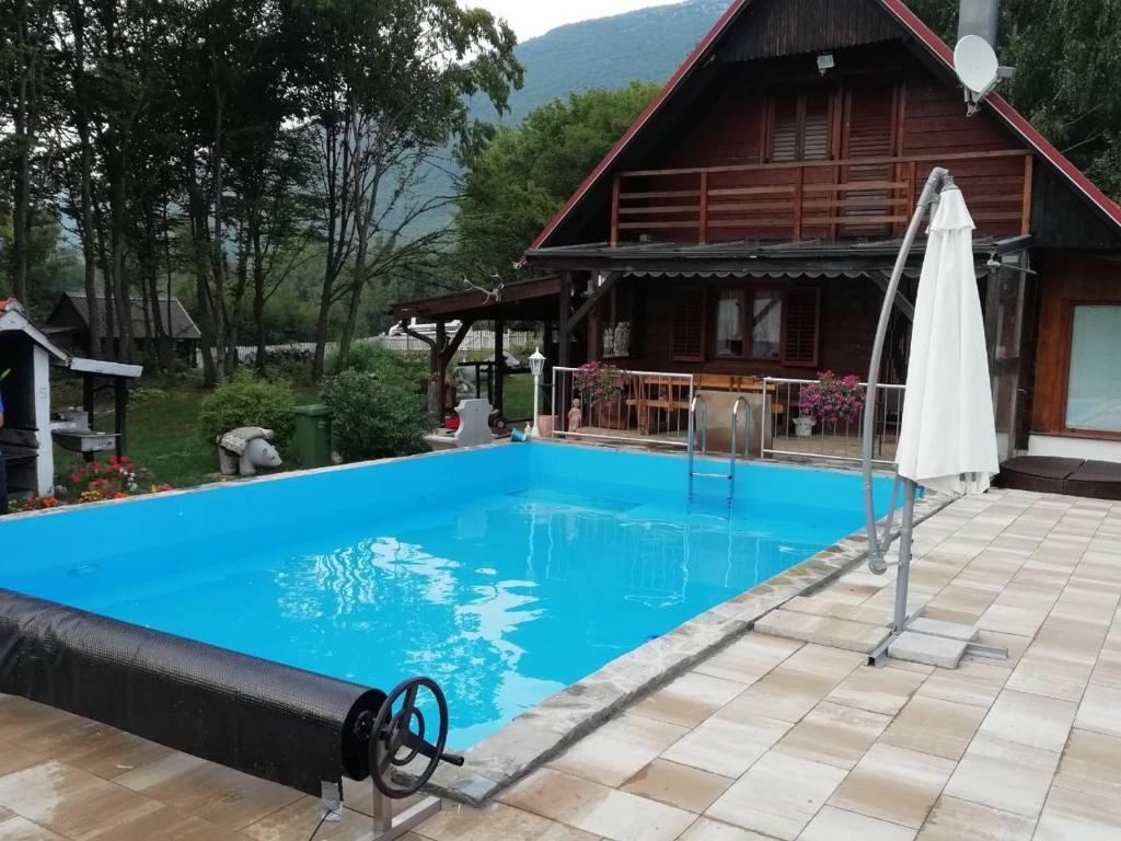 une maison avec une piscine en face d'une maison dans l'établissement Holiday House Vale Verde, à Korenica