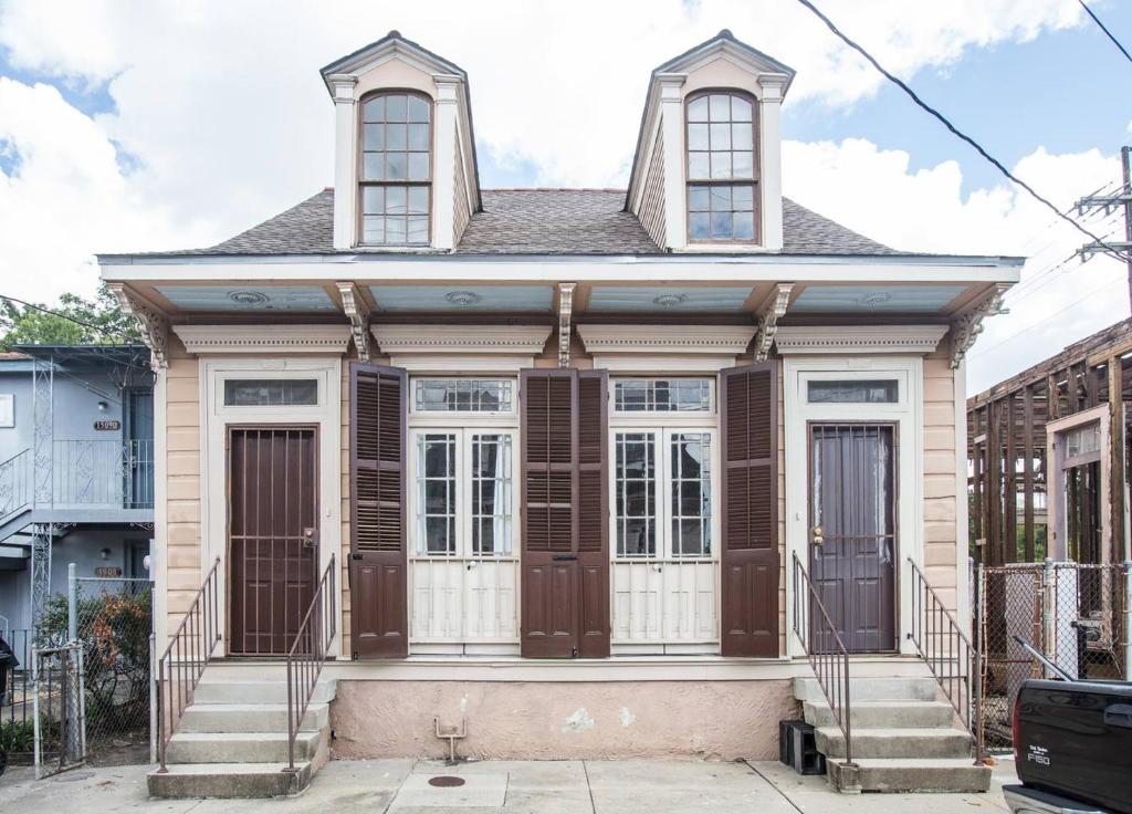 una casa vieja con puertas marrones en una calle en Perfect NOLA Hideaway en Nueva Orleans