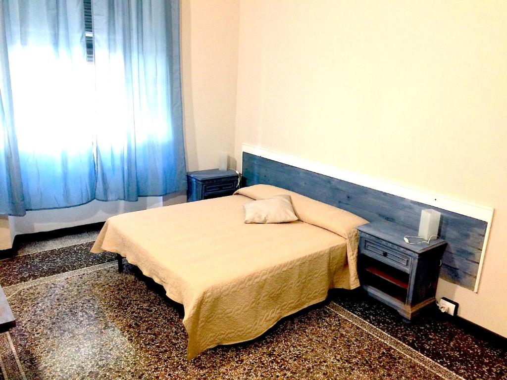 niewielka sypialnia z łóżkiem i oknem w obiekcie Le stanze della Lanterna w Genui