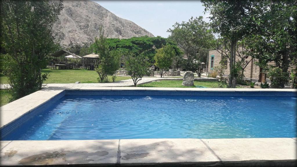 una piscina con una montagna sullo sfondo di Refugio de Santiago Ecolodge a Lunahuaná
