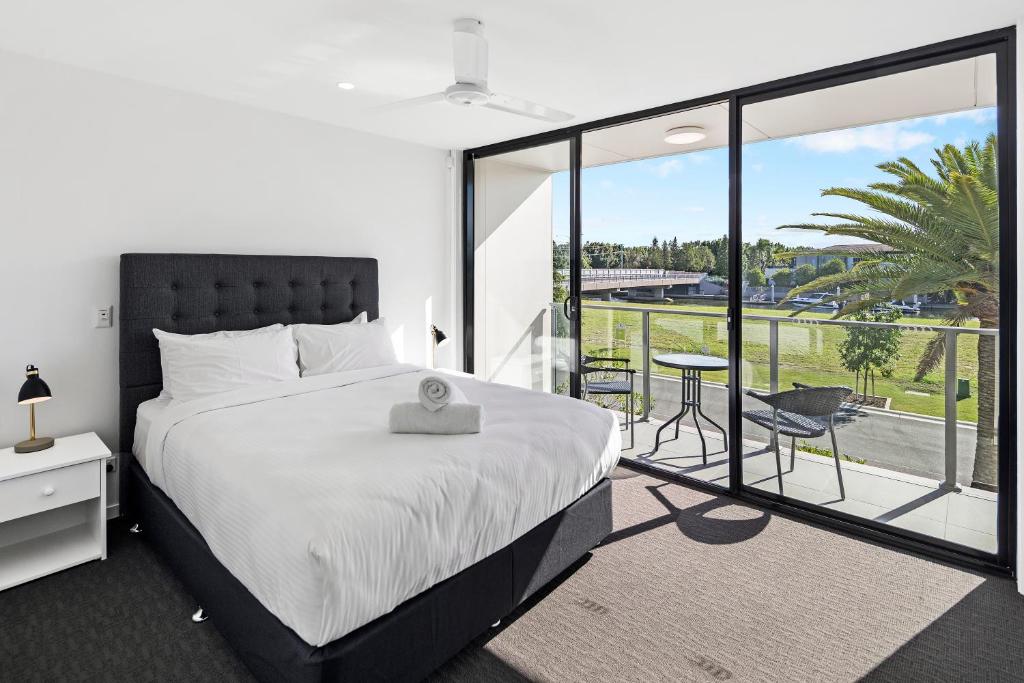 1 dormitorio con 1 cama grande y balcón en The Residences at The Peninsula en Gold Coast