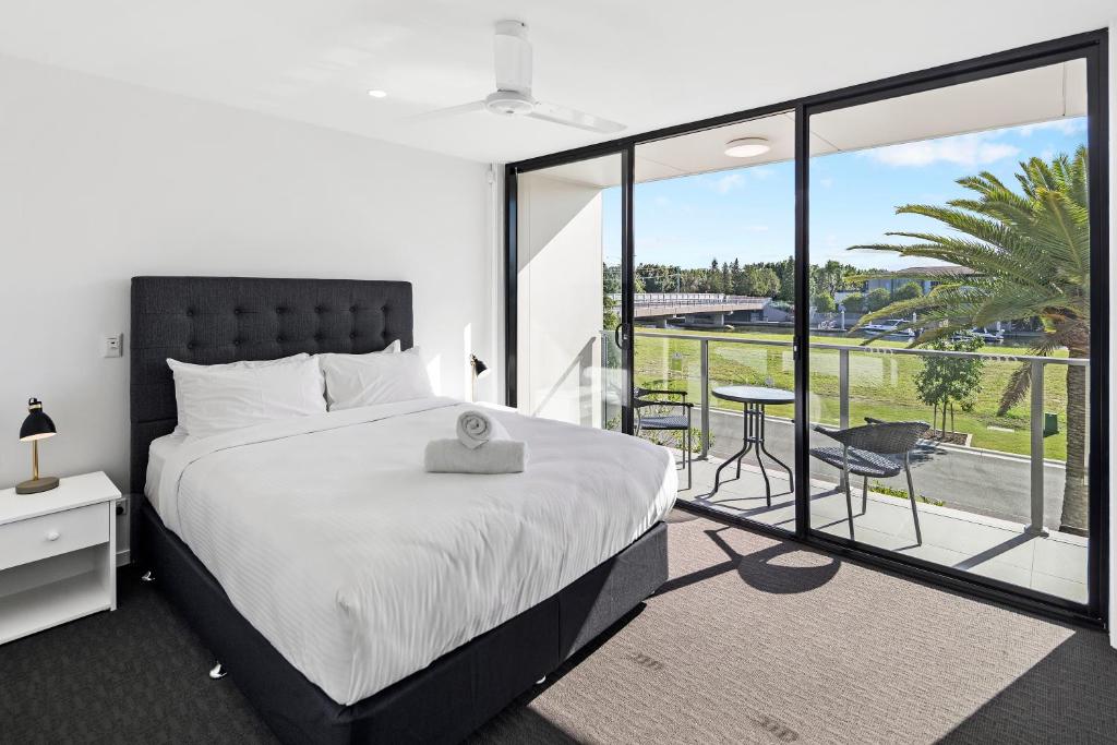 a bedroom with a large bed and a balcony at The Residences at The Peninsula in Gold Coast