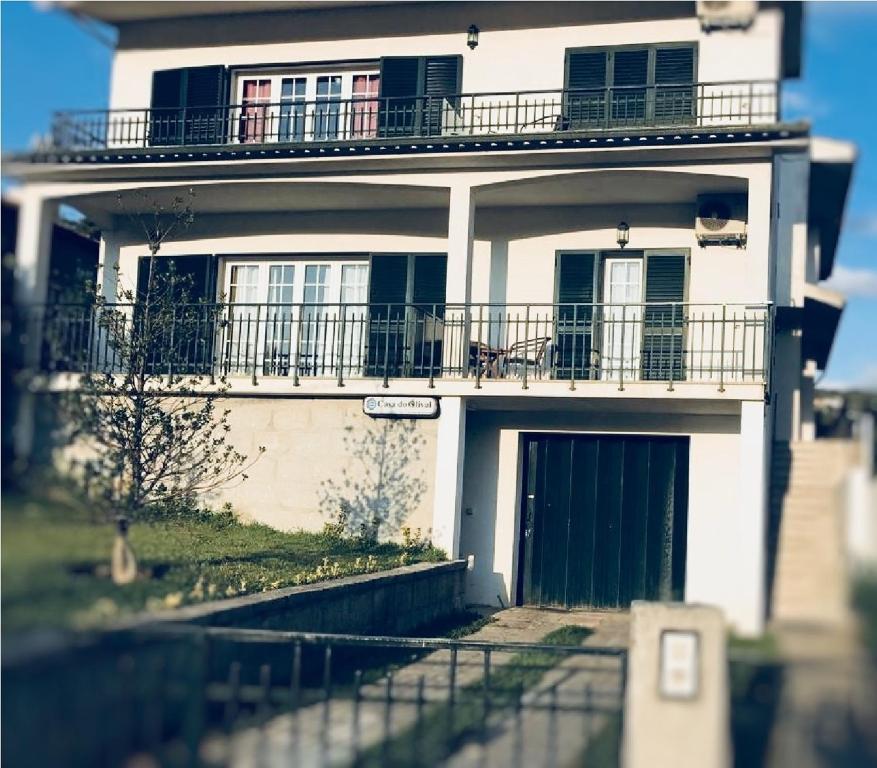 Cette maison blanche dispose d'une terrasse couverte et d'un balcon. dans l'établissement Casa do Olival, à Peso da Régua